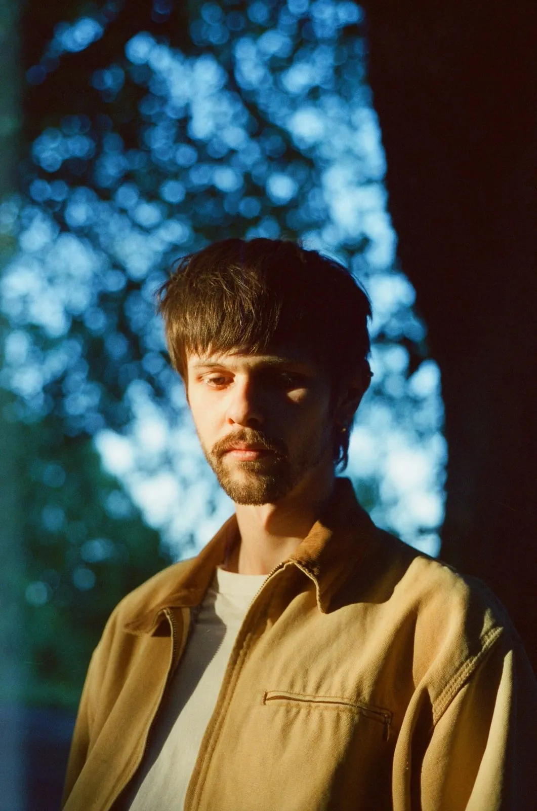 Portrait of Josh in warm light against a blue wall