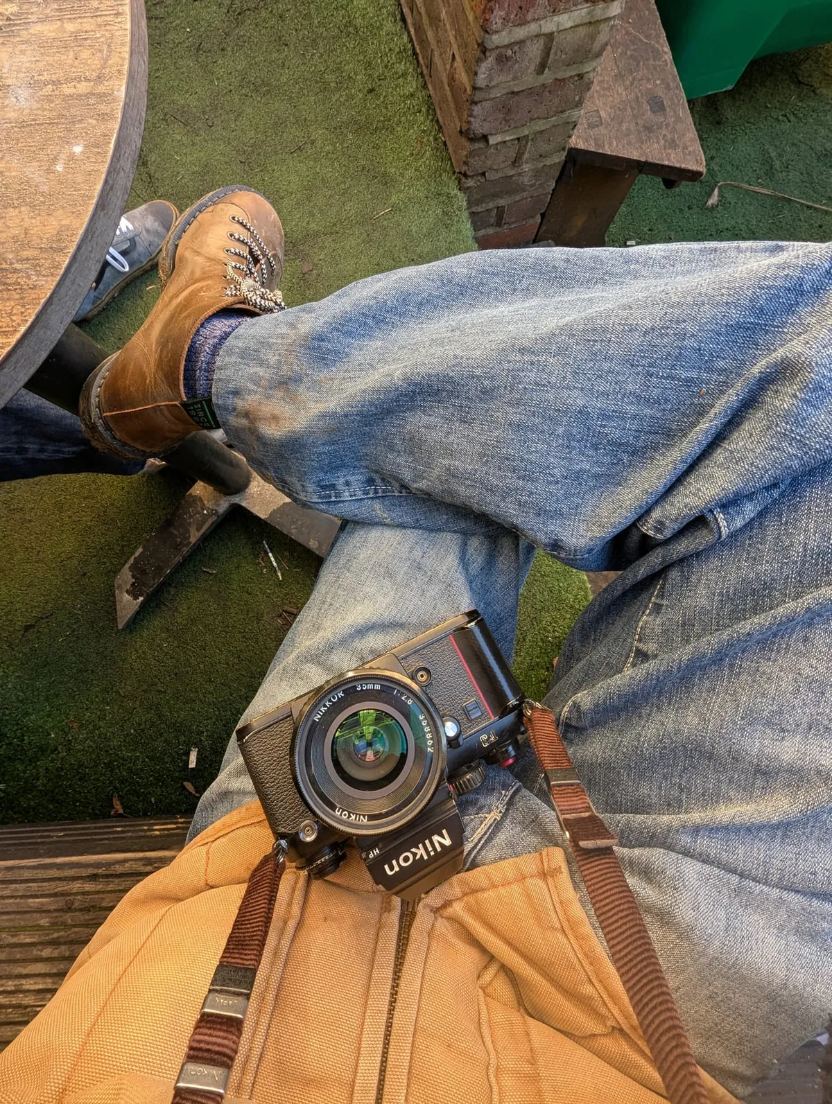 Legs crossed on a bench with a Nikon film camera in my lap