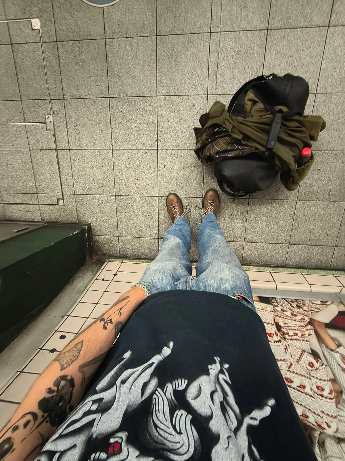 Looking down at my jeans and boots on a tiled floor