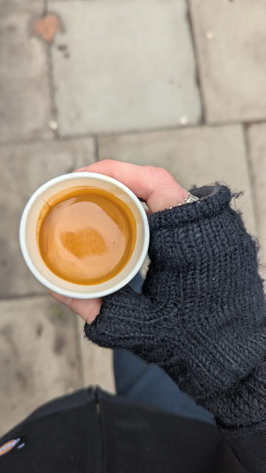 A flat white held in a fingerless glove